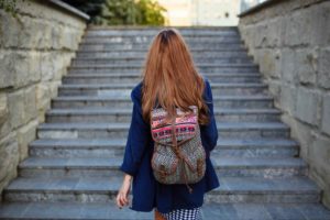 Zdjęcie dziewczyny z plecakiem idącej po schodach